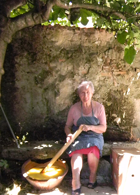 Hortensia Quintano removiendo con un palo el jabón en un balde de barro para que cuaje